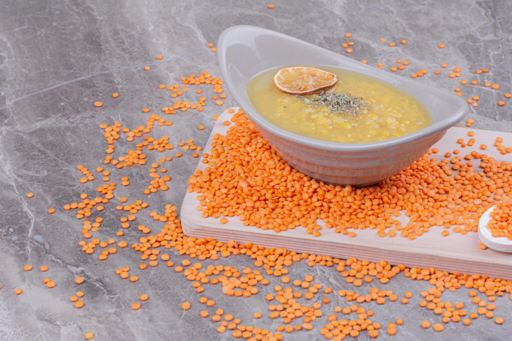 Broth soup with lemon and spices on a wooden platter